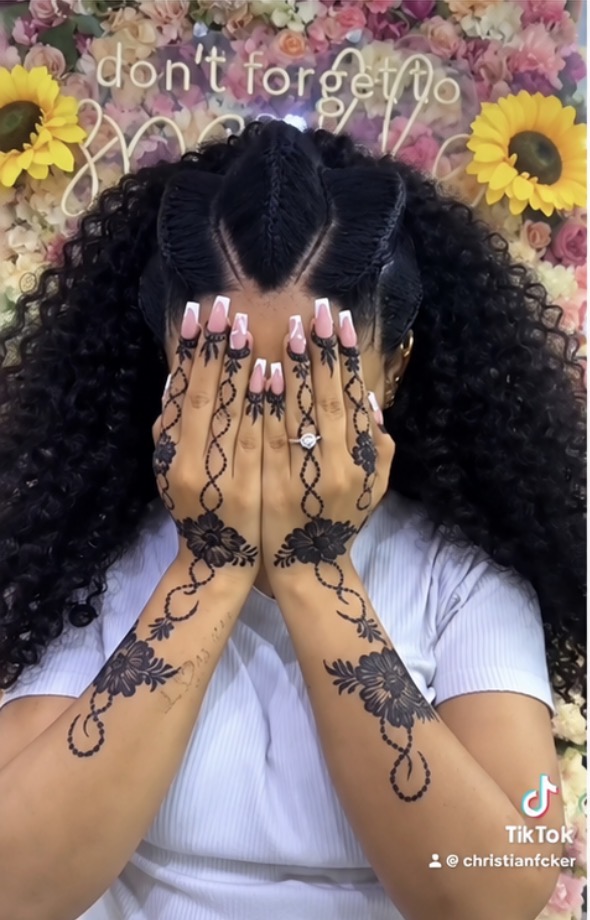 Beauty portrait with henna-decorated hands covering the face